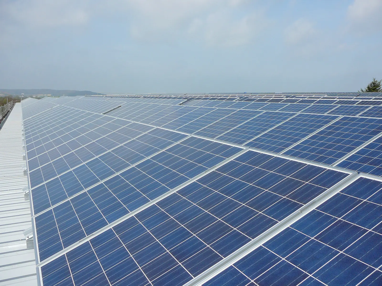 A large array of solar panels on a commercial roof